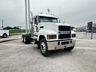 Mack PI64 cab and chassis truck in a dealership lot showing front and left side with Mack grille and bumper.