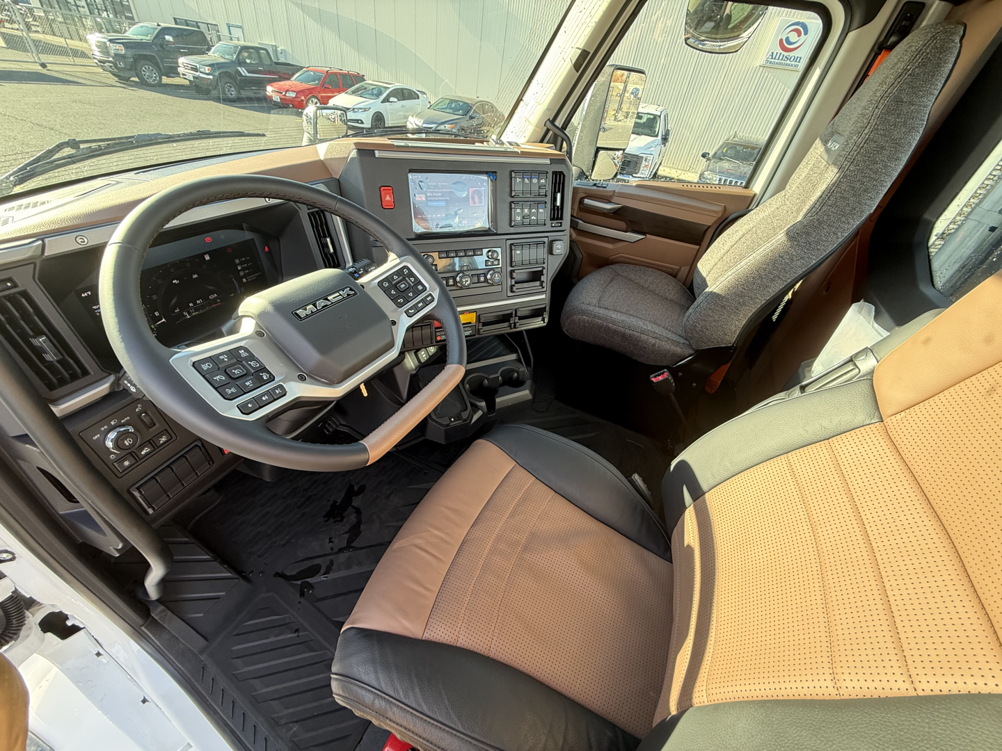 Interior of 2026 Mack PR64T showing steering wheel and driver seat with dashboard and center console.