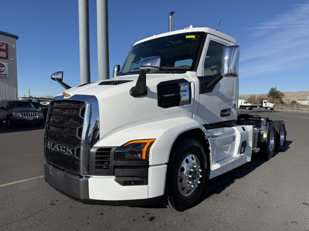 Mack PR64T truck in white, front three-quarter view, showing large grille, chrome mirrors, side steps, and dual rear axles.