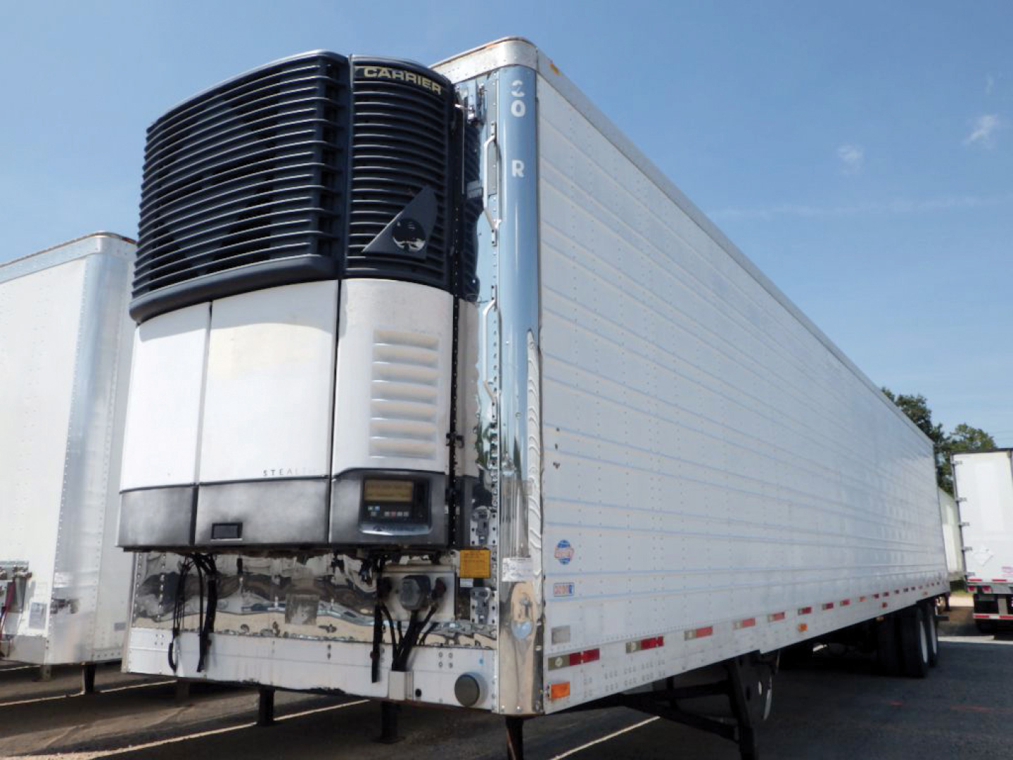 Reefer trailer with Carrier unit on front showing white and black refrigeration unit and side of trailer.