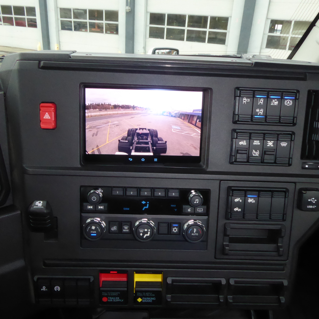 Mack PR64T dash panel showing touchscreen display and control knobs.