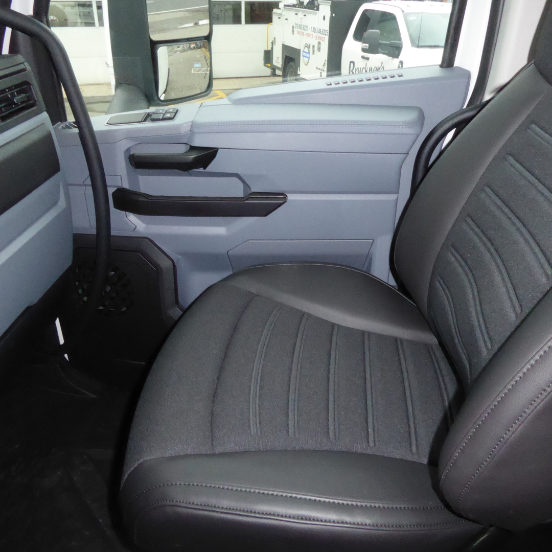 Cab interior of a new 2026 Mack PR64T truck showing front passenger seat and door panel with light gray and black trim.