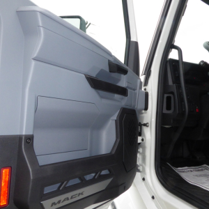 Mack PR64T truck interior door panel view showing gray plastic trim and black lower section.