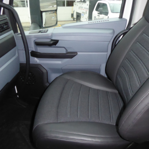 Cab interior of a new 2026 Mack PR64T truck showing front passenger seat and door panel with light gray and black trim.