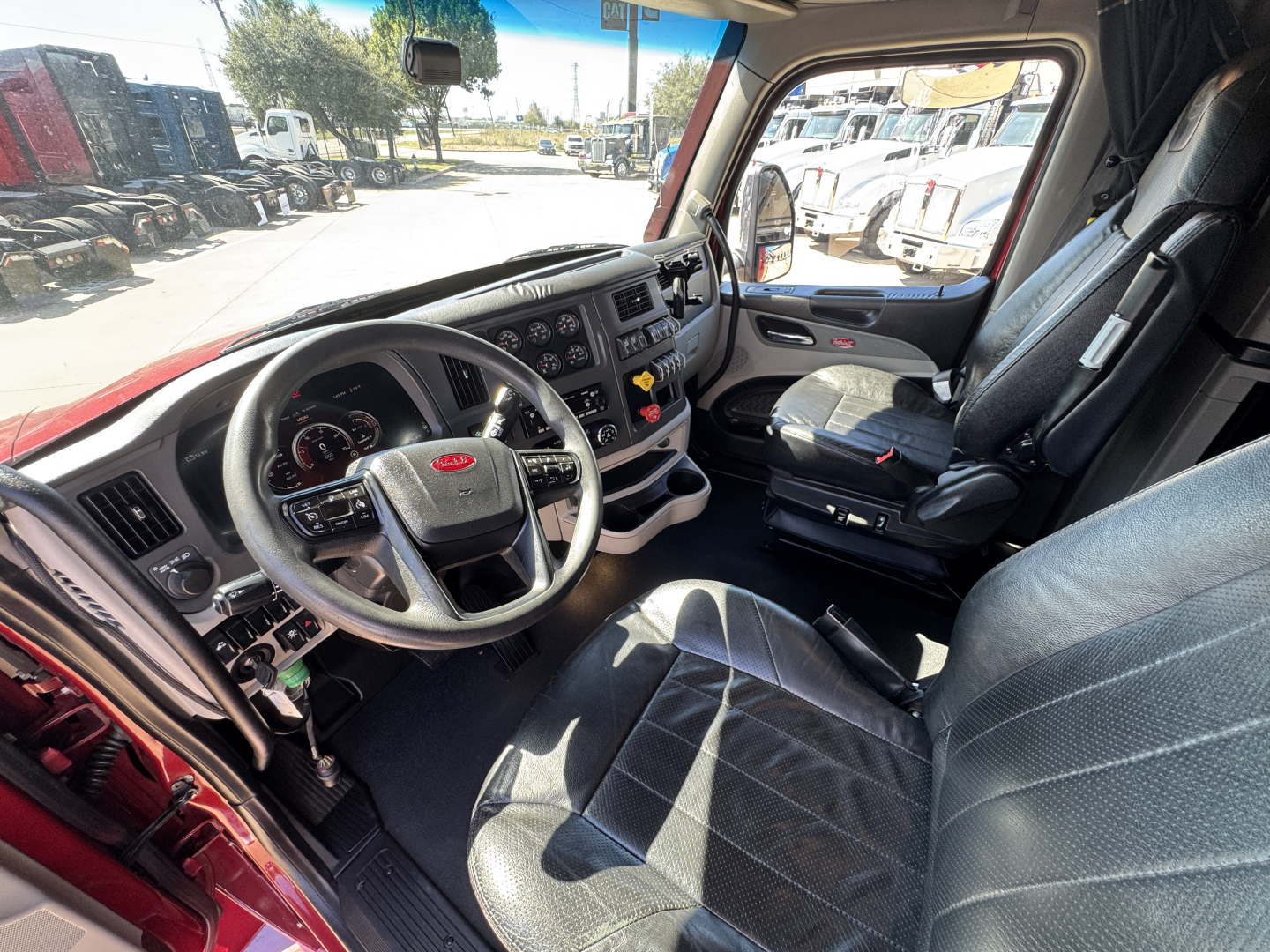 Peterbilt 579 truck interior, driver seat and dashboard view with steering wheel, gauges, and center console.