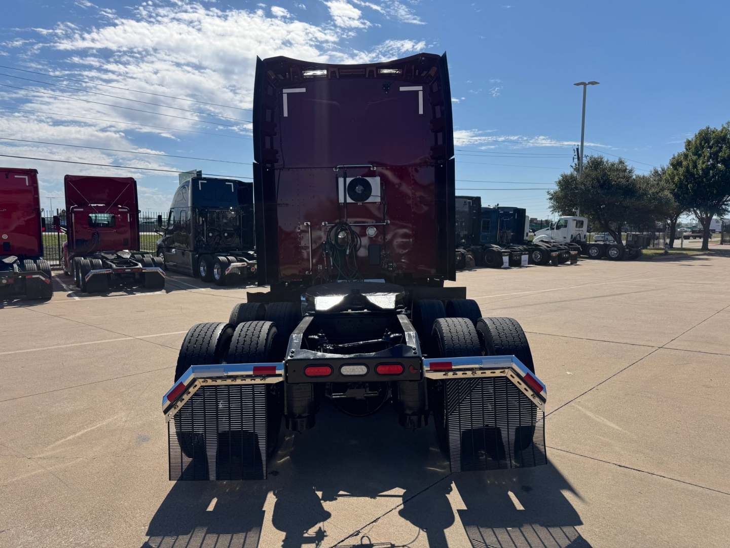 Peterbilt 579 rear view showing fifth wheel and dual rear axles in a truck lot.