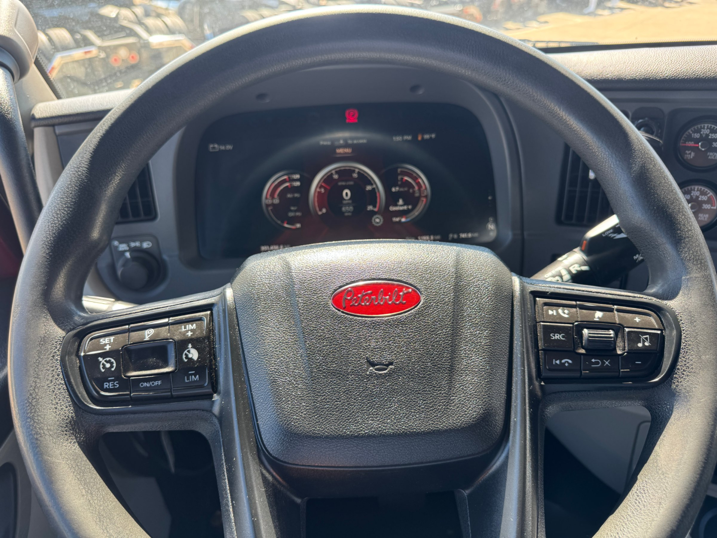 Peterbilt steering wheel and dashboard in-cab view showing instrument cluster and controls.