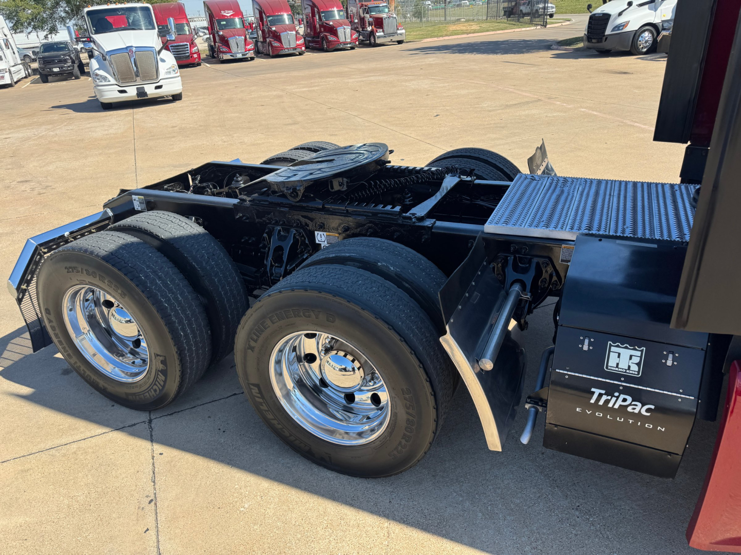 Peterbilt 579 truck chassis showing rear dual rear axles, chrome wheels, exposed frame, and TriPac power unit box on the side.