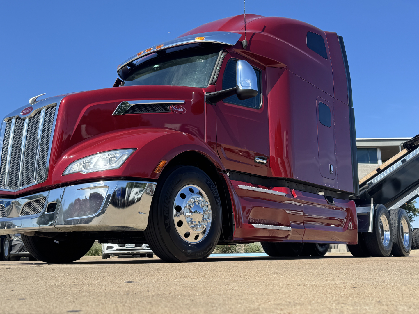 Peterbilt 579 semi-truck in red, front-left view, chrome grille, large fuel tanks, sleeper cab, VIN 1XPBDP9X4PD812733 visible on listing.