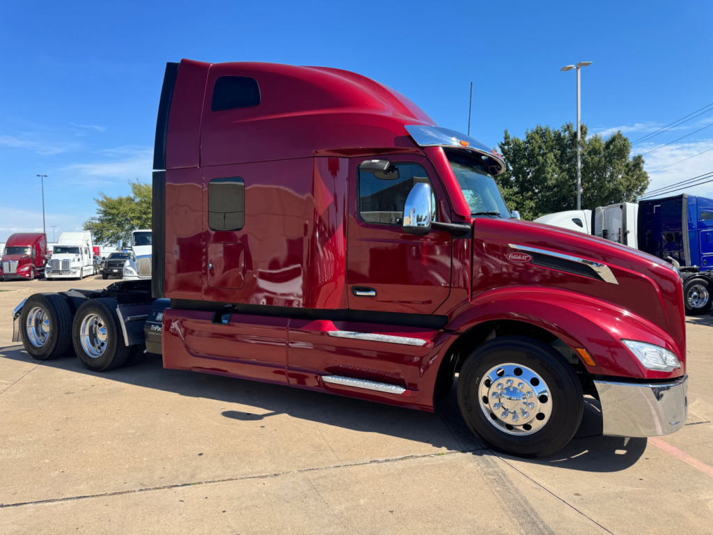 Peterbilt 579 conventional sleeper truck in red, side view showing cab, chrome wheels, and aerodynamic side skirts with Sleeper area