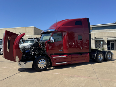 Peterbilt 579 conventional sleeper truck in red with hood open exposing engine bay and front wheels. Side view shows dual rear axles and cab doors closed.