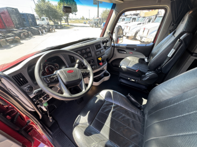 Peterbilt 579 truck interior, driver seat and dashboard view with steering wheel, gauges, and center console.