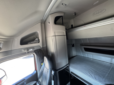 Peterbilt 579 truck sleeper cab interior showing bunk bed area and storage cabinet.