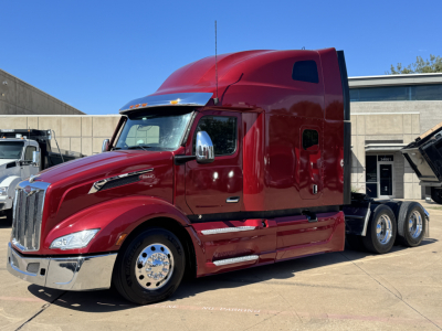 Peterbilt 579 truck with maroon cab, side view showing aerodynamic sleeper, chrome grille, and dual rear axles.