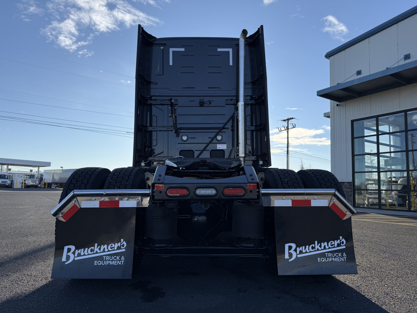 Back view of a new 2026 Mack PR64T76H conventional sleeper truck, rear chassis with dual rear tires and mud flaps labeled Bruckner’s Truck & Equipment, stock number 71511.