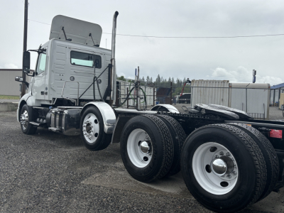 Truck chassis of a 2019 Volvo VNL84T300 conventional daycab showing rear dual wheels and fifth-wheel area with cab-side exhaust, side mirrors, and steps.