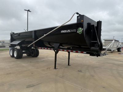 Armor Lite SHD32/48 dump trailer in a paved lot, black with white Armor Lite text, dual-axle rear, landing gear down, hitch area visible.