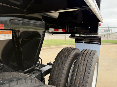 Trailer chassis and dual rear wheels of a new Armor Lite SHD32/48 dump trailer showing tandem tires and undercarriage components.