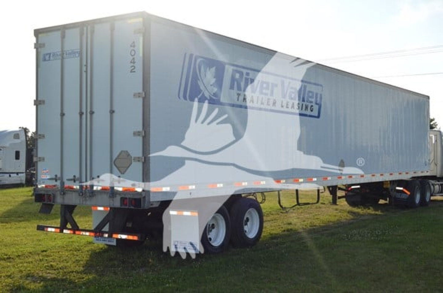 Trailer side view showing River Valley logo and tandem axles on a utility 4000Dx trailer.