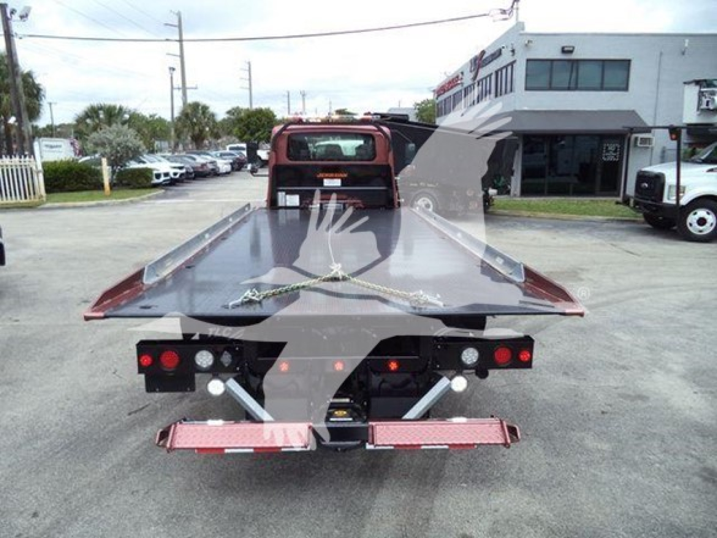 Tow truck rollback bed of a 2020 International MV rear view showing flatbed with red taillights and hydraulic components.