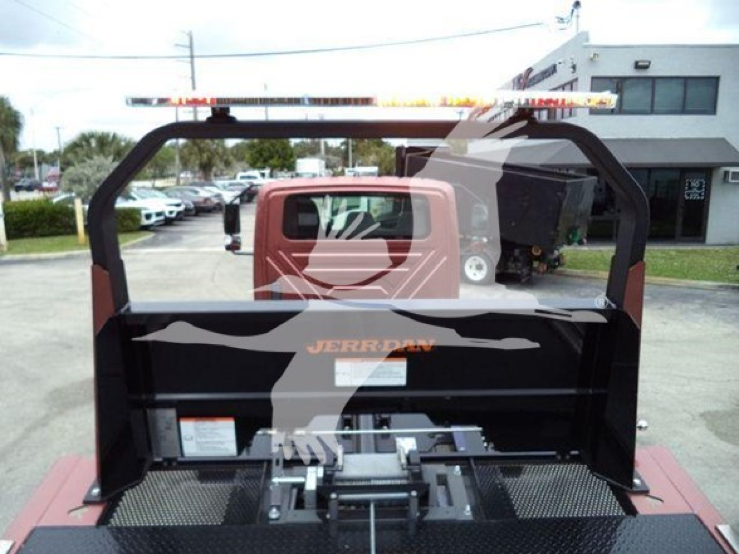 Truck bed area of a 2020 International MV rollback truck showing hydraulic controls and bed assembly.