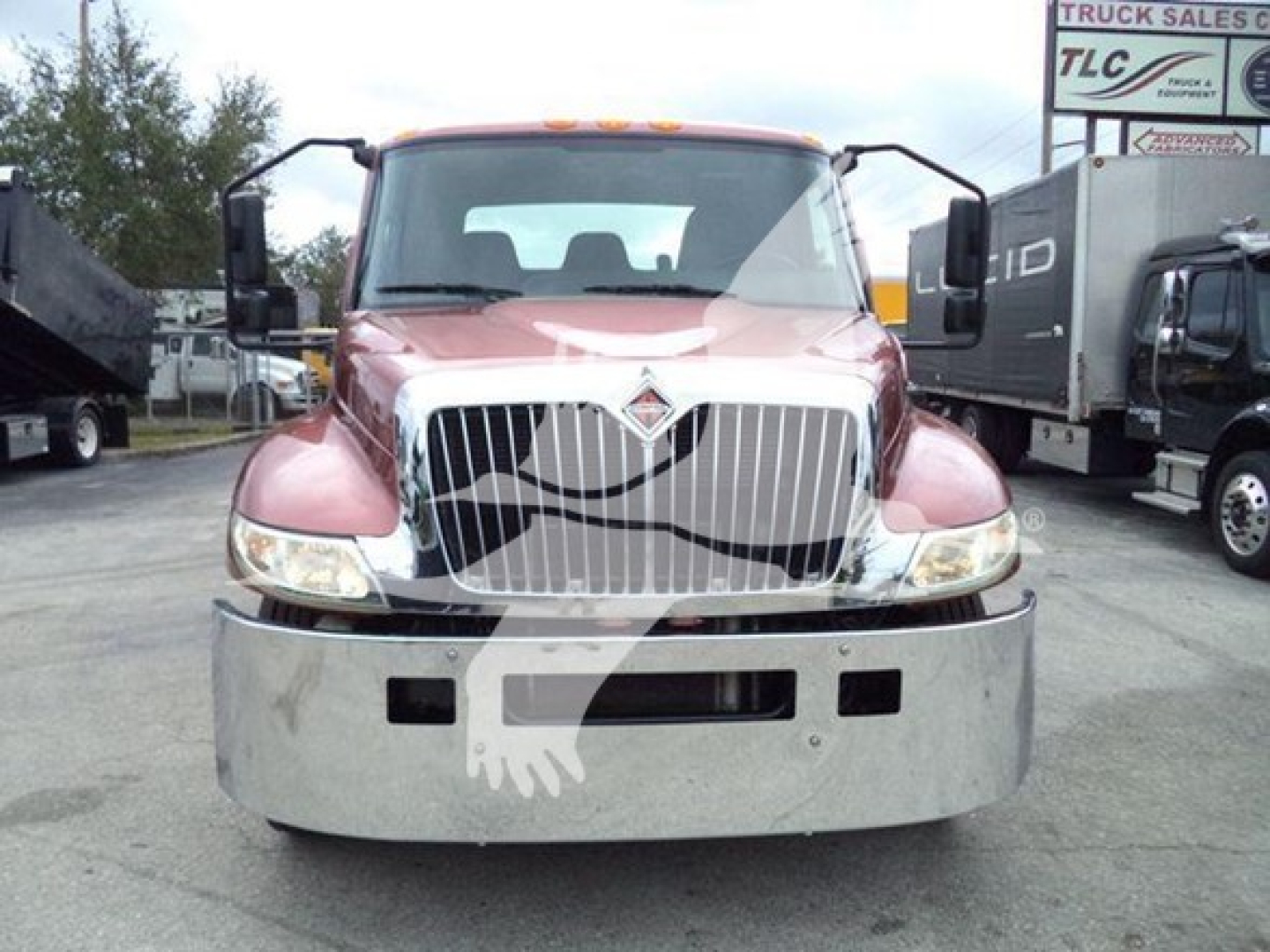 Front view of a red 2020 International MV rollback truck showing chrome grille, bumper, headlights, and side mirrors.