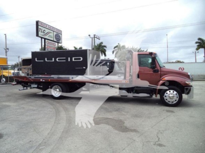 Truck cab and flatbed rollback tow truck with Lucid equipment mounted on bed, side view showing red cab and black equipment box labeled 'LUCID'.