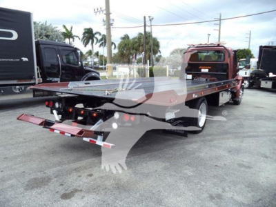 Truck bed rollback tow truck with flatbed and ramps visible.