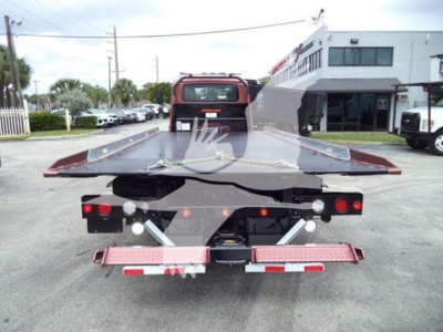 Tow truck rollback bed with rear view showing hitch, taillights, and metal ramps on the platform.