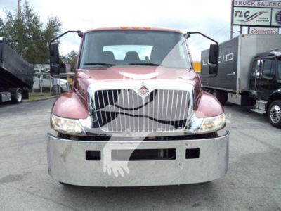 Front view of a red 2020 International MV rollback truck showing chrome grille, bumper, headlights, and side mirrors.