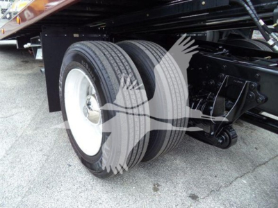 Dual rear wheels on a rollback truck chassis showing tires and suspension components undercarriage.