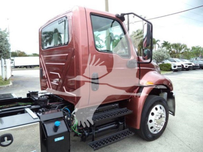 Truck cab side view of 2020 International MV with step and fuel/wuel lines visible in engine bay area; no legible labels or specs readable on image