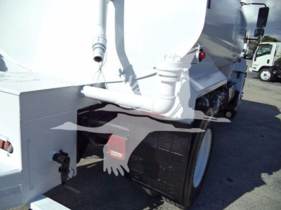 Hino 338 truck rear showing dual rear tires and white tanker body with piping and tail light.