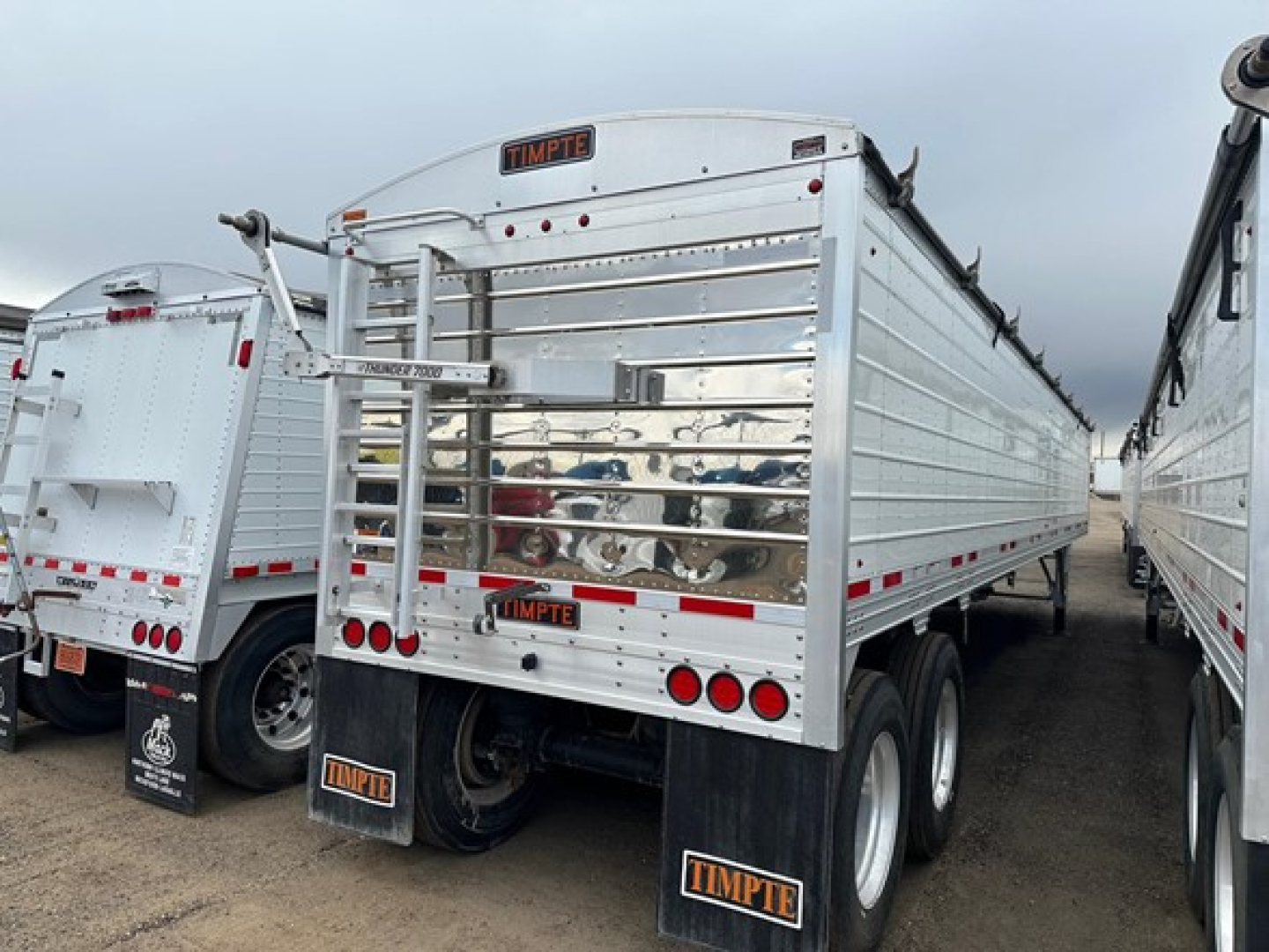 Timpte Super Hopper trailer rear view showing metal side panels, rear gate, and dual axles with mud flaps and reflectors.