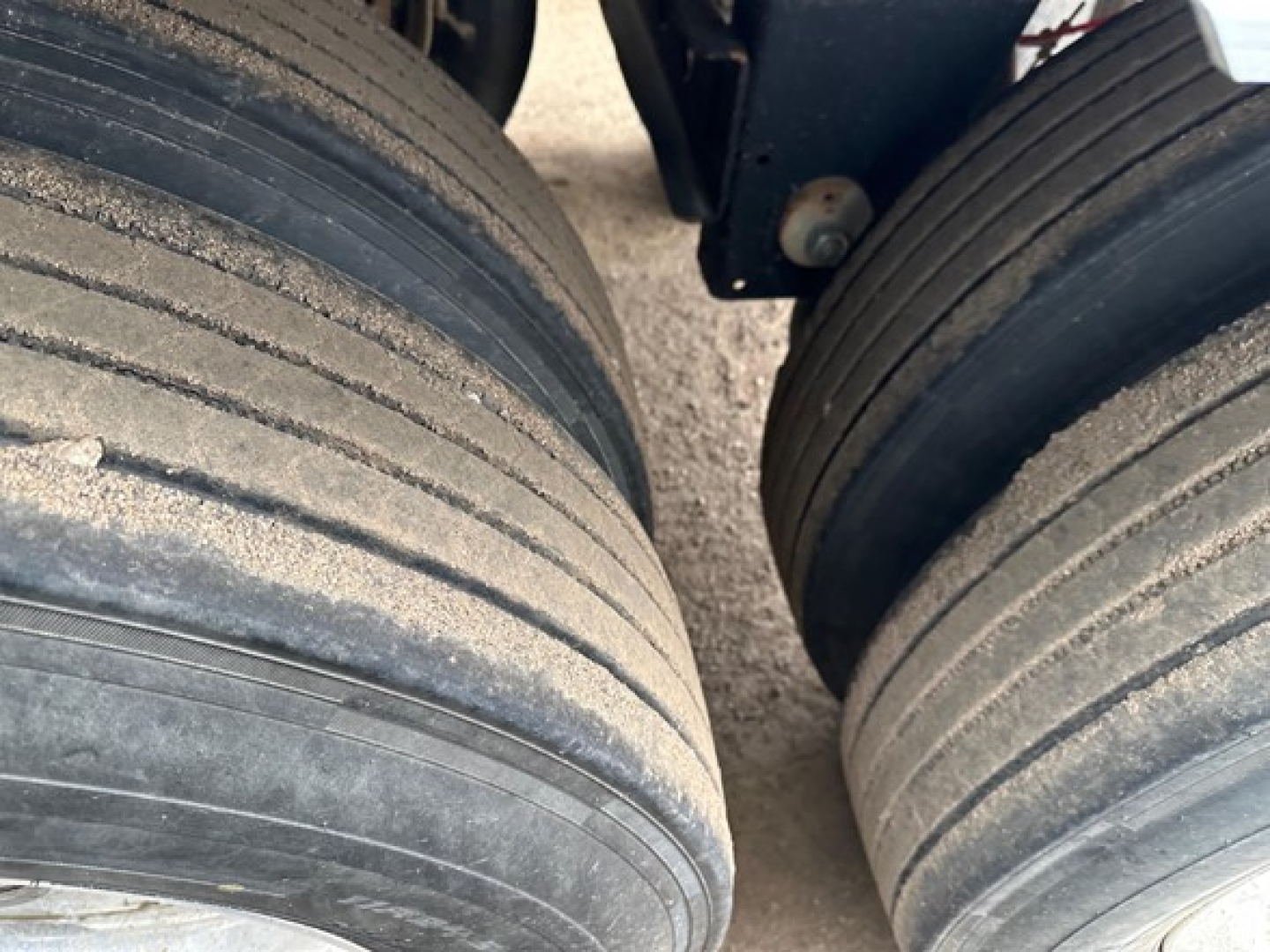 Timpte hopper trailer tires and wheel area with dust on tread, close view of dual rear axle tires.
