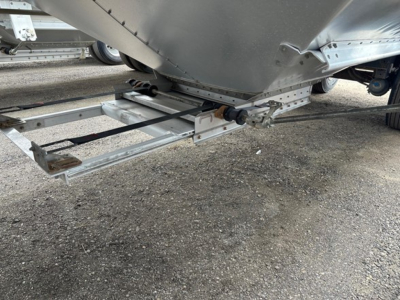 Hopper trailer undercarriage showing structural frame and pivot links of a 2024 Timpte Super Hopper; metal framing and hitch area visible.