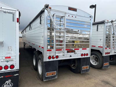 Timpte Super Hopper trailer rear view showing dual axle, metal siderails, tailgate with Timpte branding, and mudflaps with Timpte logo.