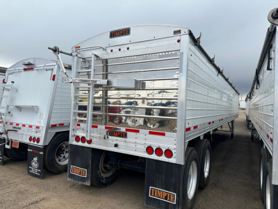 Timpte hopper trailer rear view showing aluminum side panels and rear gate with TIMPTE branding and brake lights.