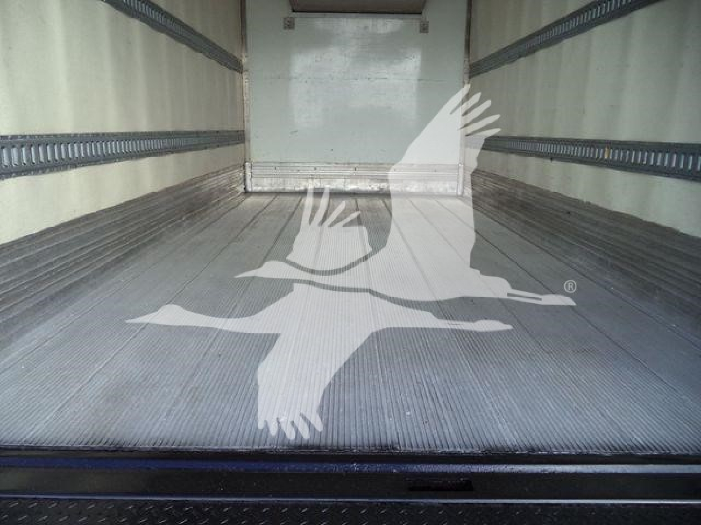 Truck bed interior of a 2020 Hino 195 refrigerated truck showing empty aluminum floor and side rails.
