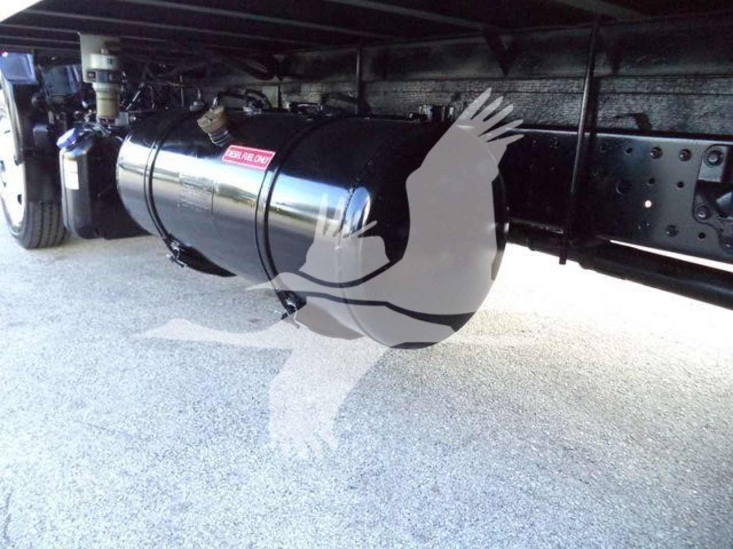 Undervehicle fuel tank and chassis of a 2020 Hino 195 refrigerated truck showing cylindrical silver fuel tank with mounting straps.