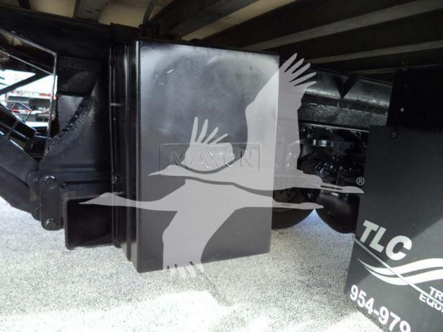 Hino 195 refrigerated truck undercarriage showing hydraulic system component and black protective housing with TLC branding partially visible.