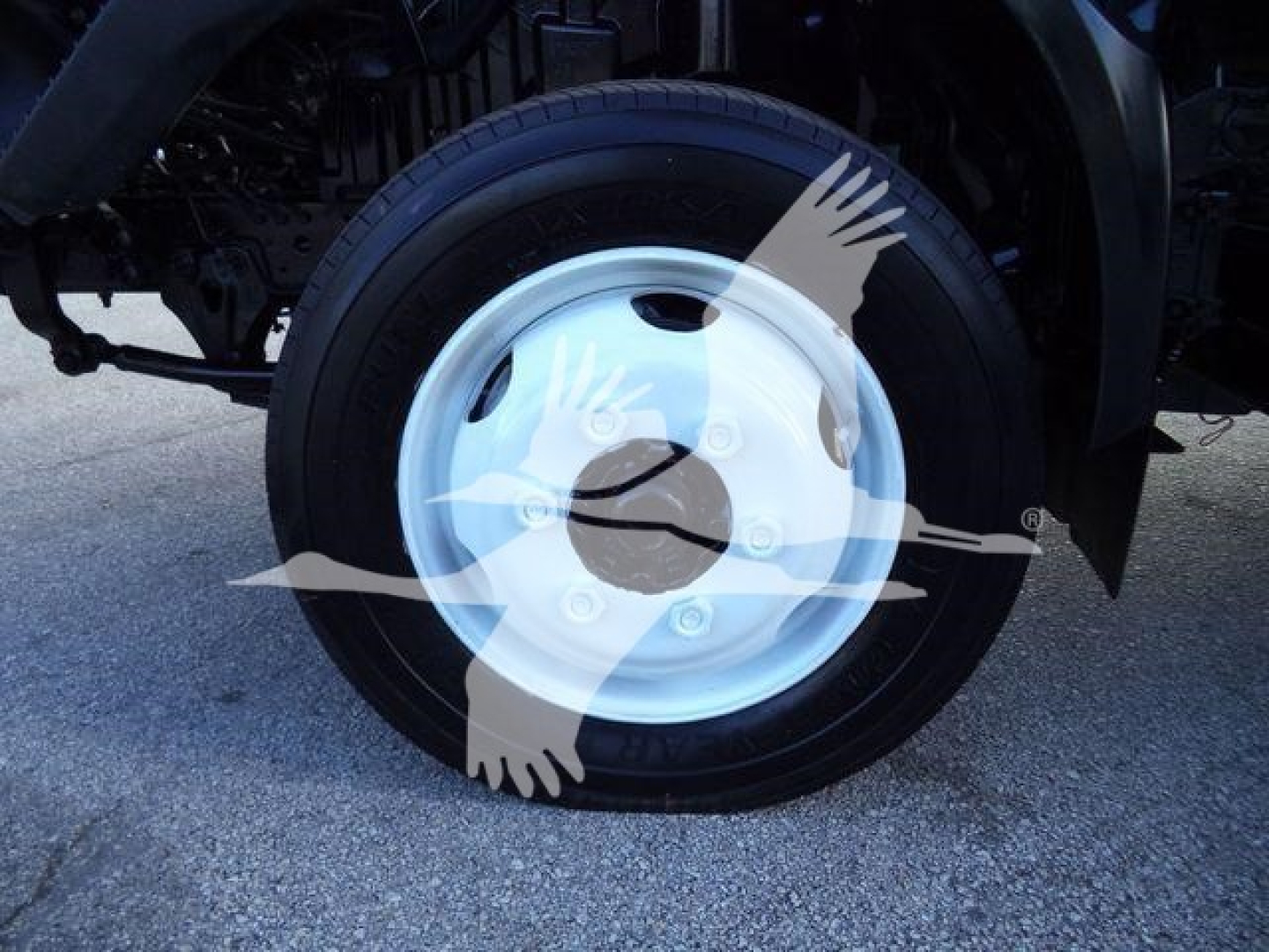 Wheel of a 2020 Hino 195 refrigerated truck showing a white steel rim and black tire with partial underbody components.