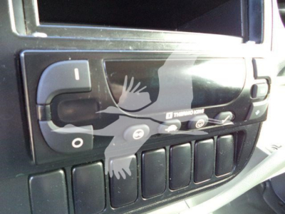 Dashboard close-up showing control switches and blank display in a refrigerated truck cab.
