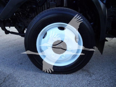 Wheel of a 2020 Hino 195 refrigerated truck showing a white steel rim and black tire with partial underbody components.