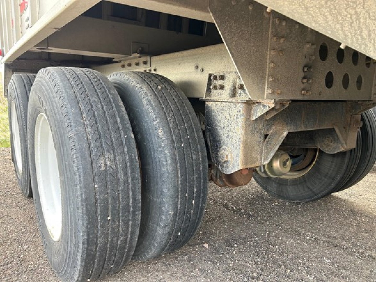 Cornhusker air ride grain hopper trailer wheel assembly showing dual rear axles and suspension.