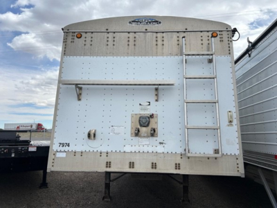 Trailer rear view showing Cornhusker logo, ladder on right, access door, tandems not visible, riveted metal sides, and identification numbers 7974.
