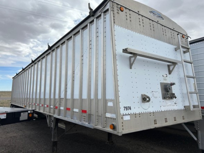 Cornhusker air ride grain hopper trailer side and rear showing aluminum sides, rear hatch, ladder, and branding plate.