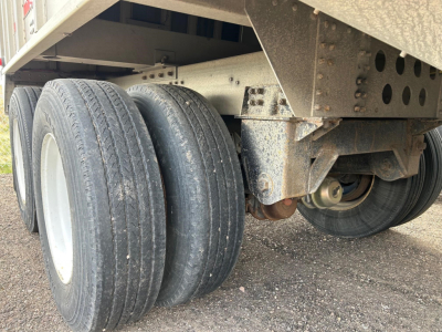 Cornhusker air ride grain hopper trailer axle and suspension with dual rear tires and undercarriage components.