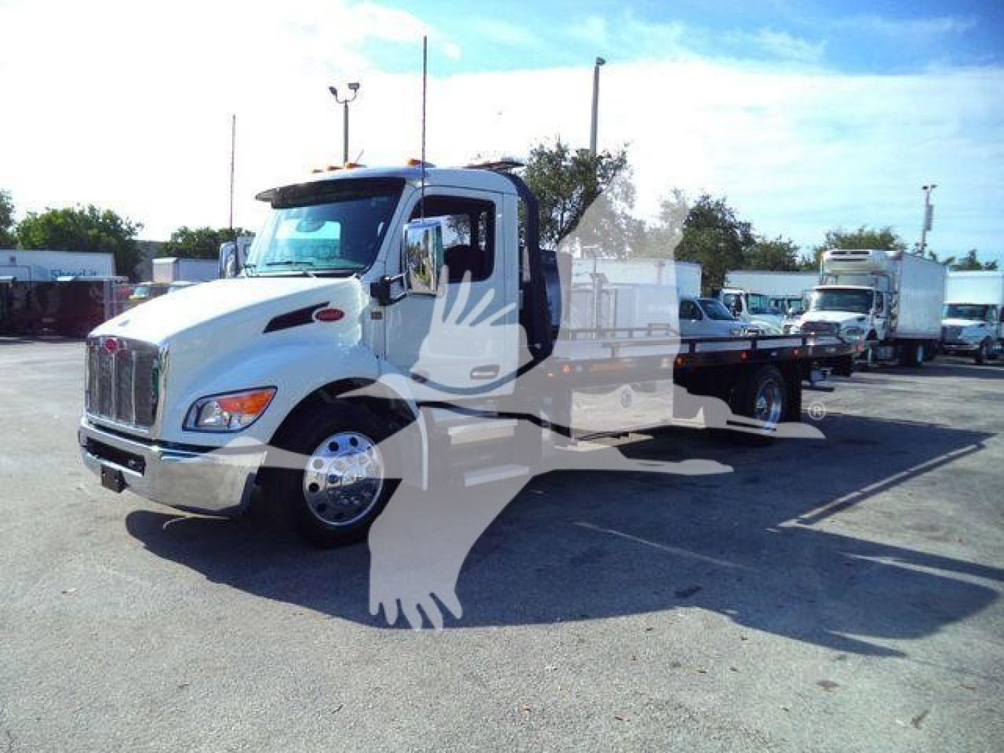 Truck image showing a white 2026 Peterbilt 536 rollback chassis with open cab and flatbed, side view, in a dealership lot.