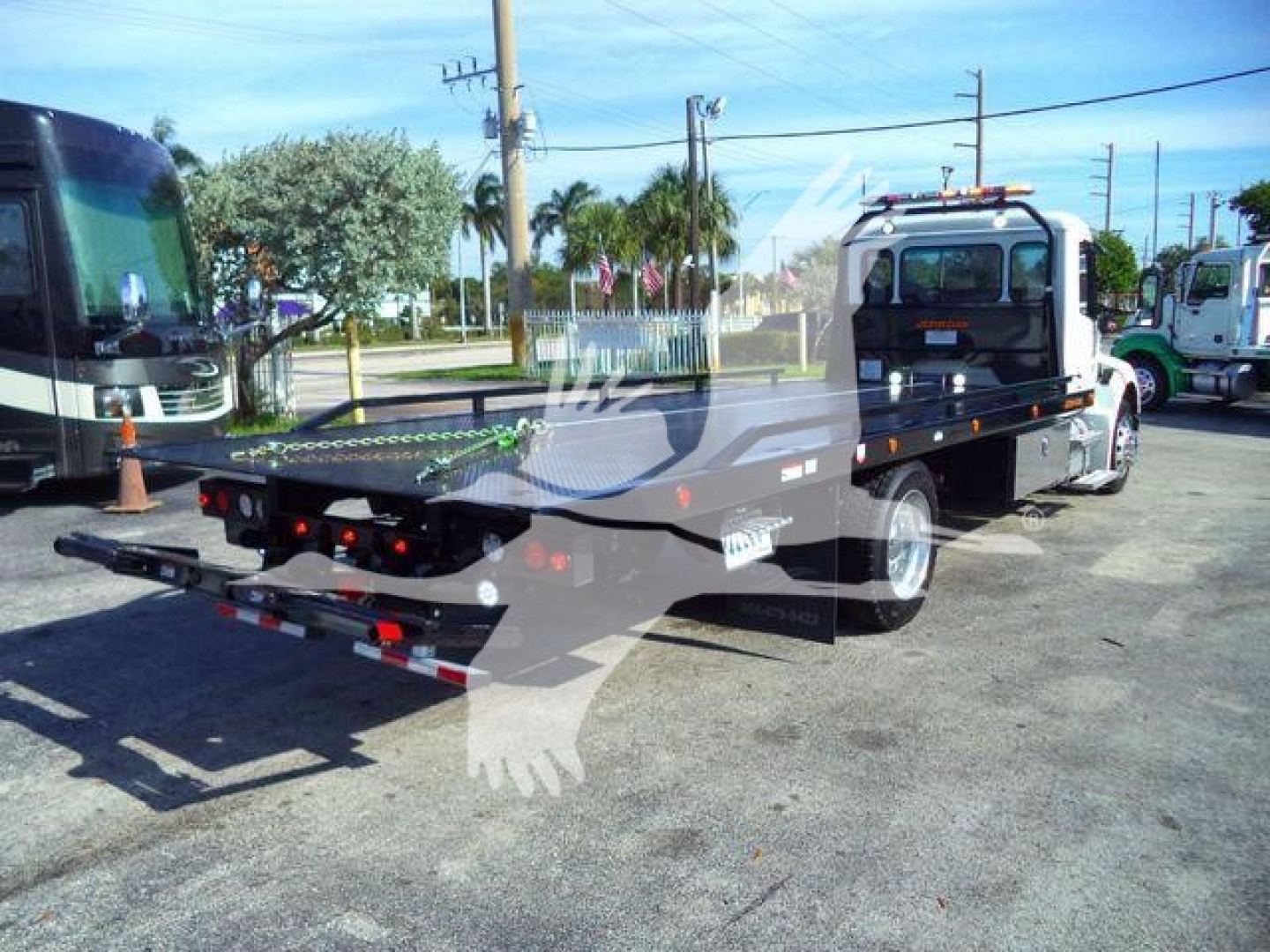 Truck bed of a Peterbilt rollback tow truck, rear view with flatbed and equipment mounts visible.